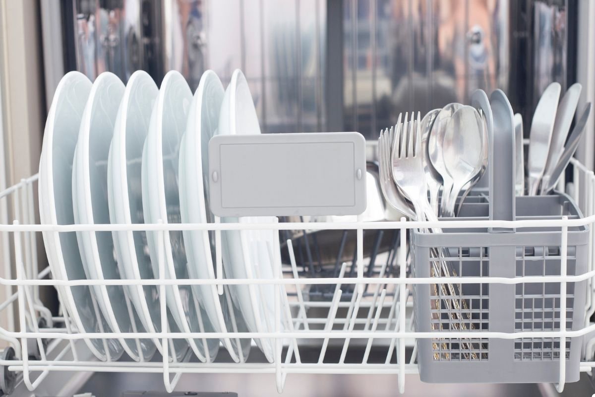 A dishwasher filled with neatly arranged silverware and plates, ready for a thorough cleaning cycle.