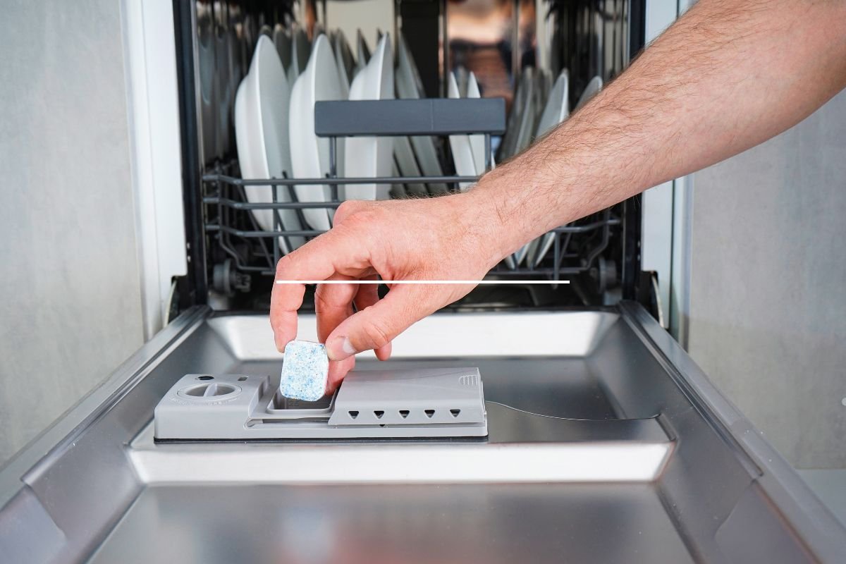 A person operates a dishwasher, efficiently cleaning dishes in a modern kitchen setting, showcasing appliance repair service expertise.